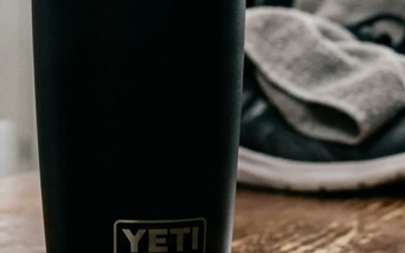 Insulated 20 oz travel tumbler on locker bench